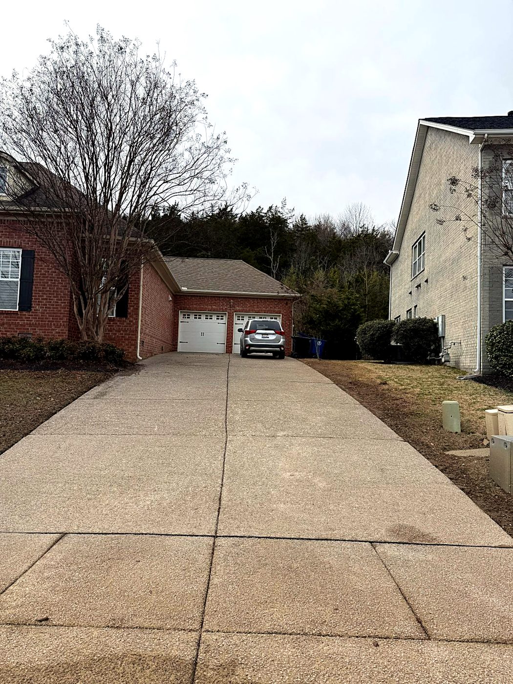 Long concrete driveway up to a two-car garage